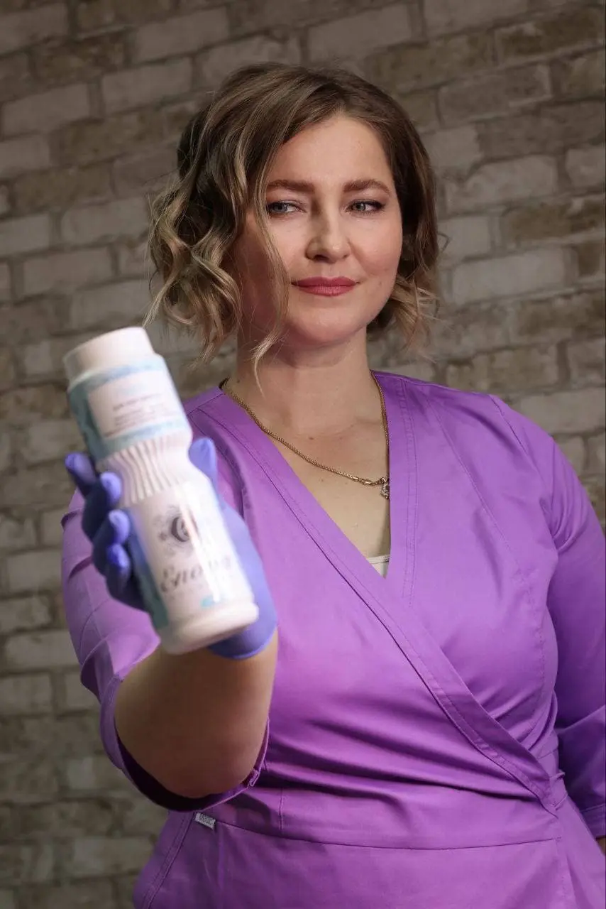 Майстер тримає косметичний засіб в руці.